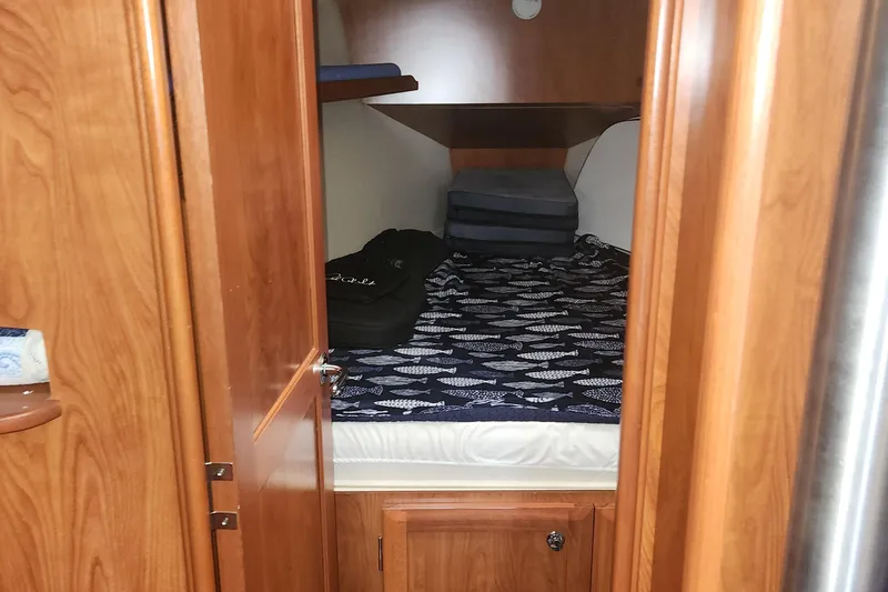 Slide: The Image of Cozy cabin interior of 2011 Hunter 39 sailboat with wooden finish and patterned bedding. - 11