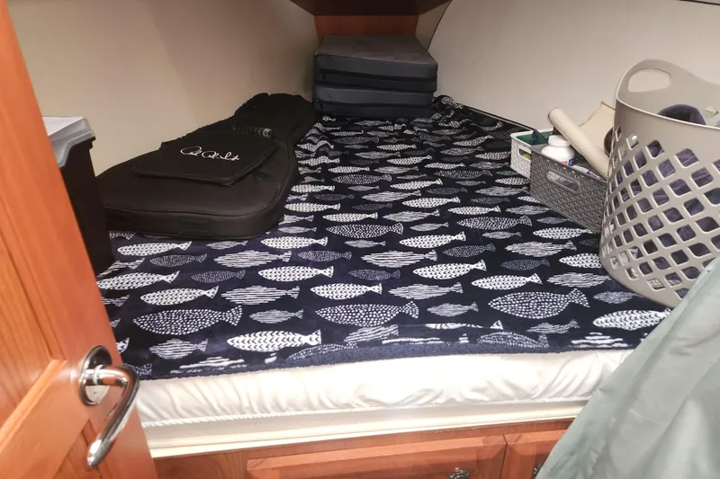 Slide: The Image of Cozy cabin interior of 2011 Hunter 39 sailboat with fish-patterned bedding and storage items. - 12