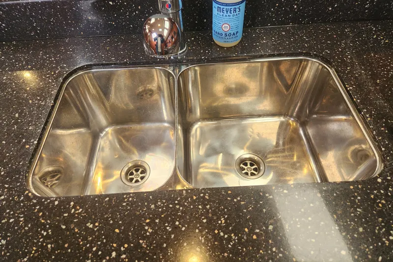 Slide: The Image of Stainless steel double sink with speckled countertop, featuring a faucet and hand soap. - 16