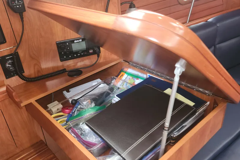 Slide: The Image of Open wooden storage compartment on 2011 Hunter 39 yacht, containing office supplies and electronics. - 21