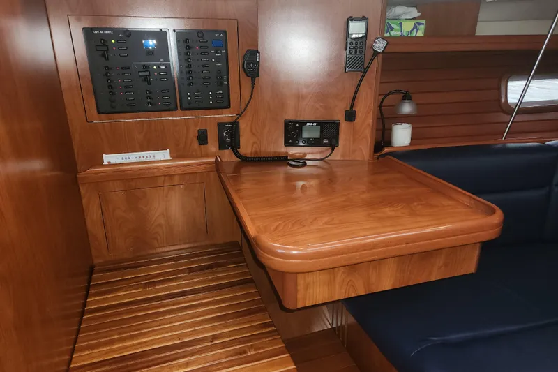 Slide: The Image of 2011 Hunter 39 yacht interior with navigation panel and wooden table. - 22
