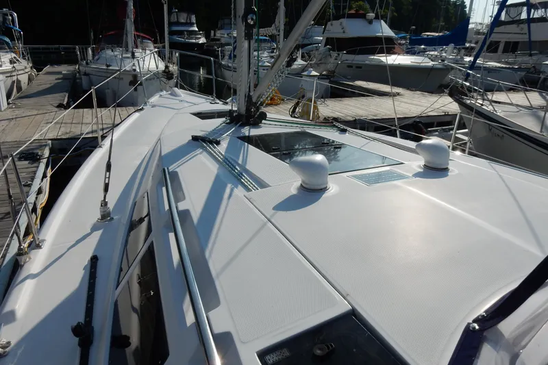 Slide: The Image of 2011 Hunter 39 sailboat deck view at marina, surrounded by other boats. - 37
