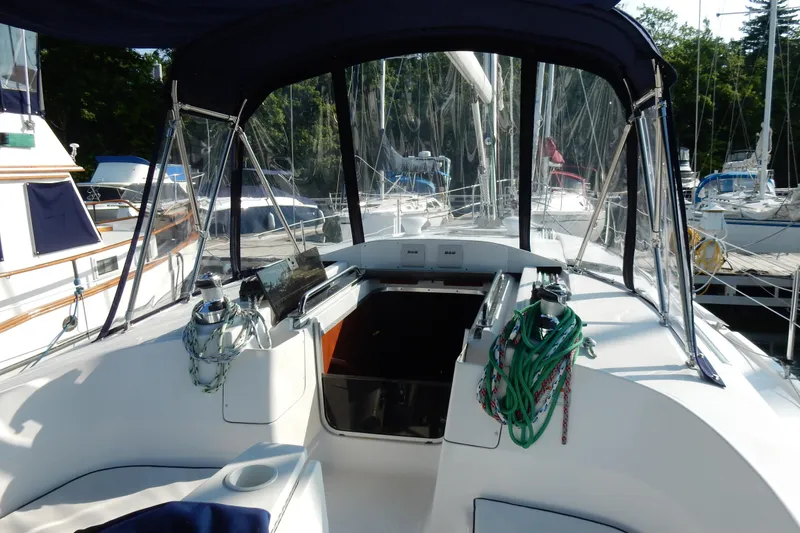 Slide: The Image of 2011 Hunter 39 sailboat cockpit with canopy, docked at marina. - 47