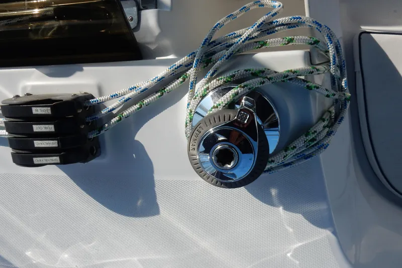 Slide: The Image of Close-up of a 2011 Hunter 39 sailboat winch with ropes and labeled clutches. - 49