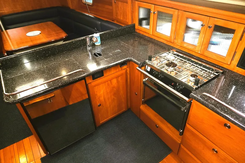 Slide: The Image of Luxurious 2011 Hunter 39 yacht kitchen with sleek countertops and wooden cabinetry. - 5