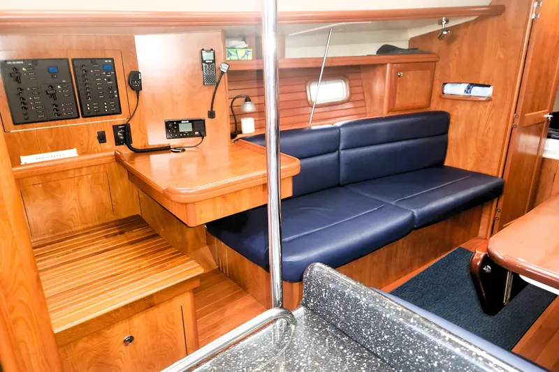 Slide: The Image of Interior of 2011 Hunter 39 sailboat with wood finish and blue seating. - 6