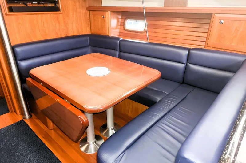Slide: The Image of Luxurious 2011 Hunter 39 yacht interior with blue leather seating and wooden dining table. - 7