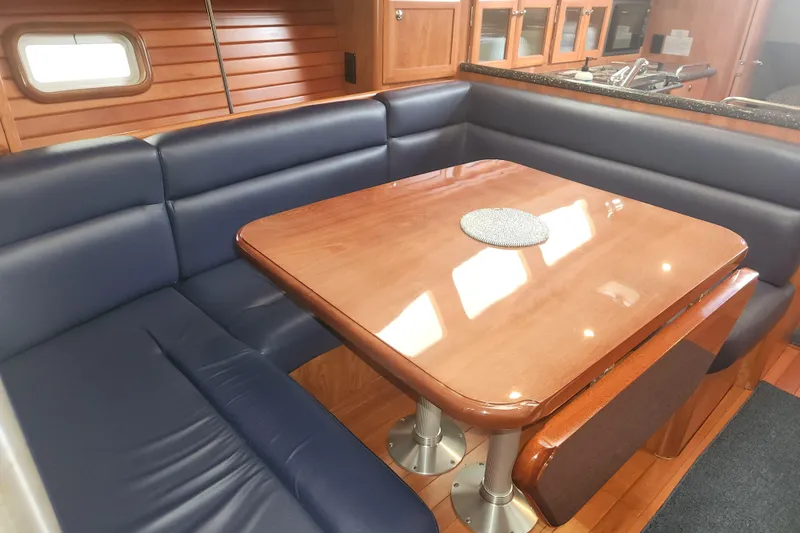 Slide: The Image of Luxurious 2011 Hunter 39 yacht interior with blue seating and wooden dining table. - 8