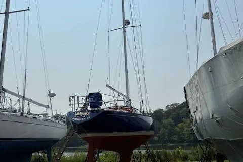 Slide: The Image of 1984 Catalina 38 sailboat on land, surrounded by other boats. - 1