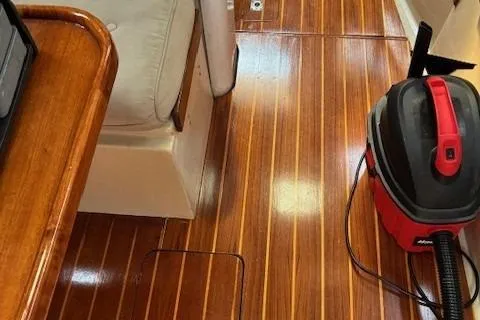 Slide: The Image of Interior of 1984 Catalina 38 sailboat with polished wooden flooring and a vacuum cleaner. - 15