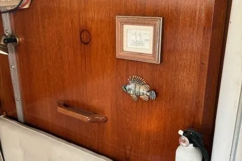 Slide: The Image of Wooden interior of 1984 Catalina 38 sailboat with fish decor and fire extinguisher. - 22