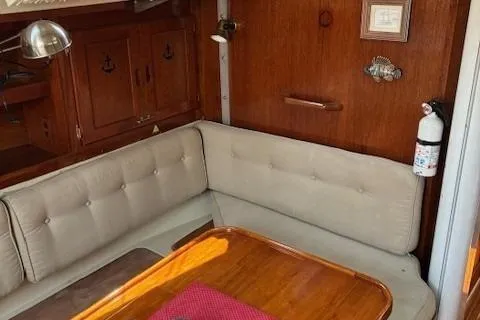 Slide: The Image of 1984 Catalina 38 yacht interior with beige seating and wooden table. - 4