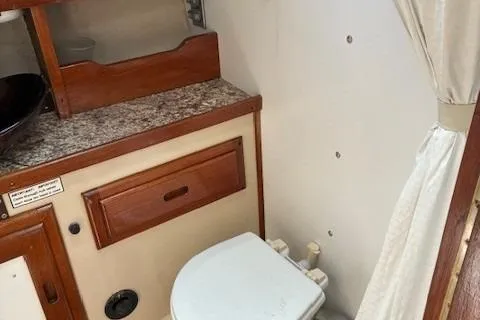 Slide: The Image of 1984 Catalina 38 boat bathroom with wooden cabinetry and compact toilet. - 5