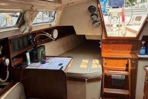 Slide: The Image of Interior of a 1984 Catalina 38 sailboat with cozy seating and navigation instruments. - 9