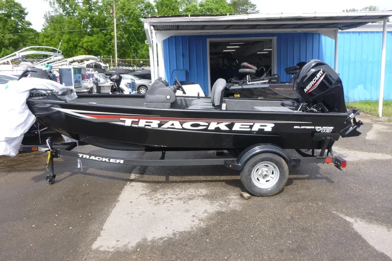 The Image of 2026 Tracker Super Guide V-16 SC boat on trailer, parked outdoors. - 1