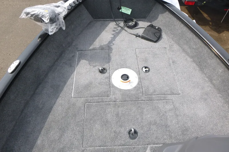 Slide: The Image of 2026 Tracker Super Guide V-16 SC boat interior with carpeted deck and storage compartments. - 7