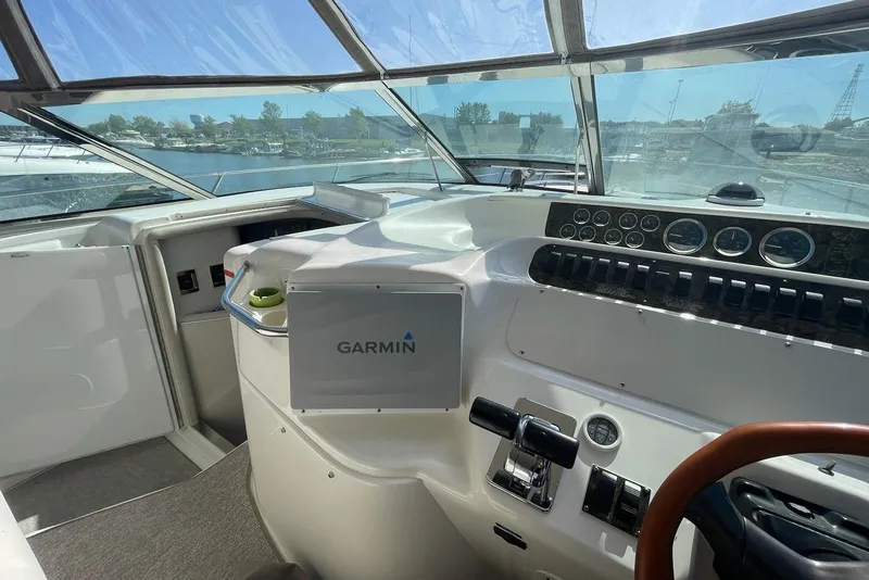 Slide: The Image of 1997 Sea Ray 400 Sundancer helm with Garmin navigation, overlooking marina. - 10