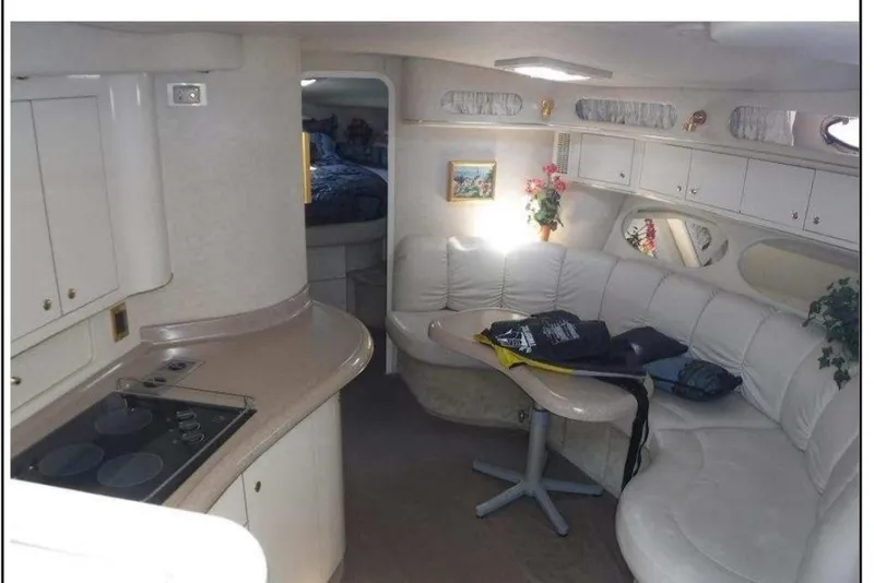 Slide: The Image of Interior of 1997 Sea Ray 400 Sundancer yacht with white seating and compact kitchen area. - 3