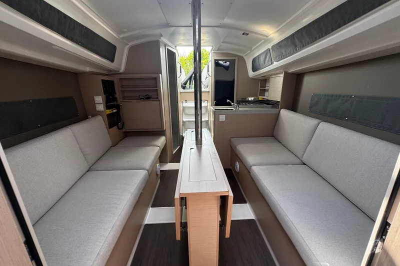 Slide: The Image of Interior of 2020 Beneteau Oceanis 30.1 sailboat with modern seating and compact kitchen. - 10