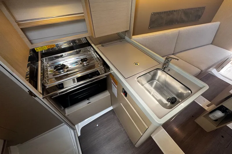 Slide: The Image of Compact kitchen area in a 2020 Beneteau Oceanis 30.1 yacht with stove and sink. - 14