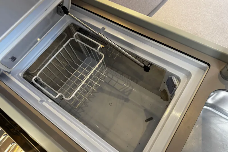 Slide: The Image of Open refrigerator compartment on 2020 Beneteau Oceanis 30.1 yacht, featuring a wire basket. - 15