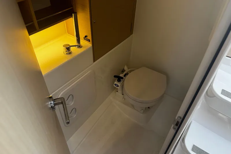 Slide: The Image of Compact bathroom in 2020 Beneteau Oceanis 30.1 yacht with toilet and illuminated sink. - 16