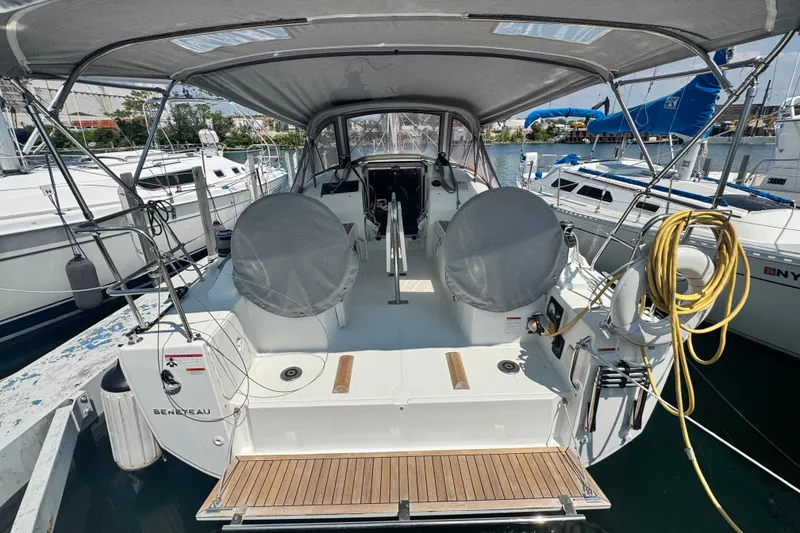Slide: The Image of 2020 Beneteau Oceanis 30.1 sailboat docked, featuring covered cockpit and dual steering wheels. - 2