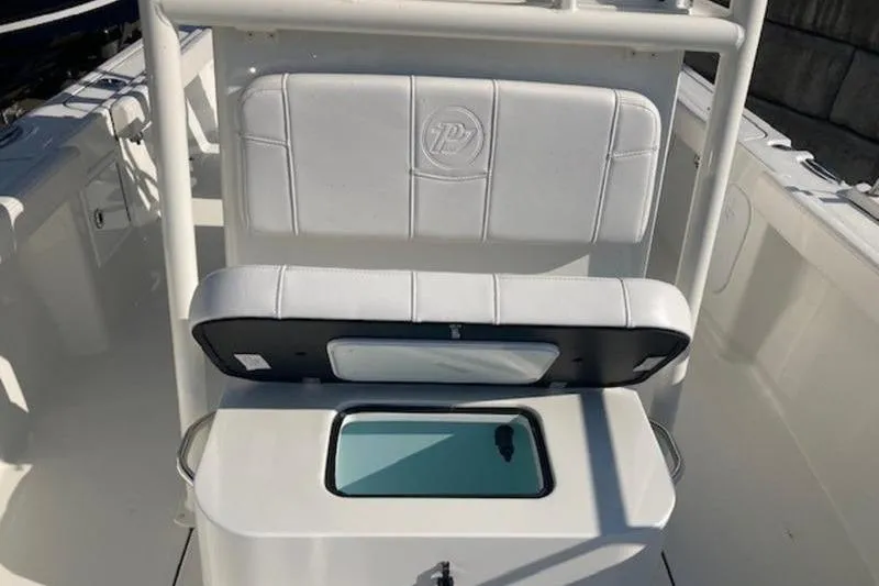 Slide: The Image of 2025 Parker 23 SE CC boat interior with white cushioned seating and storage compartment. - 13
