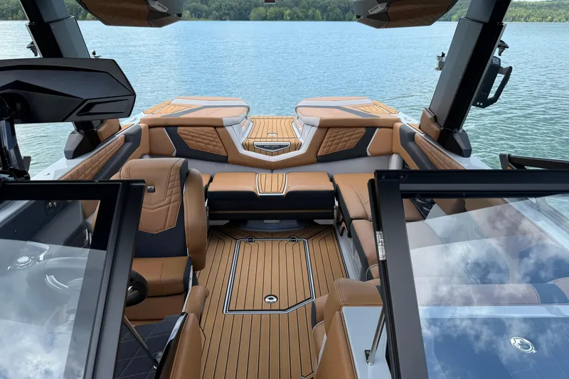 Slide: The Image of 2024 Nautique Super Air Nautique G21 interior with luxurious seating on a serene lake. - 8