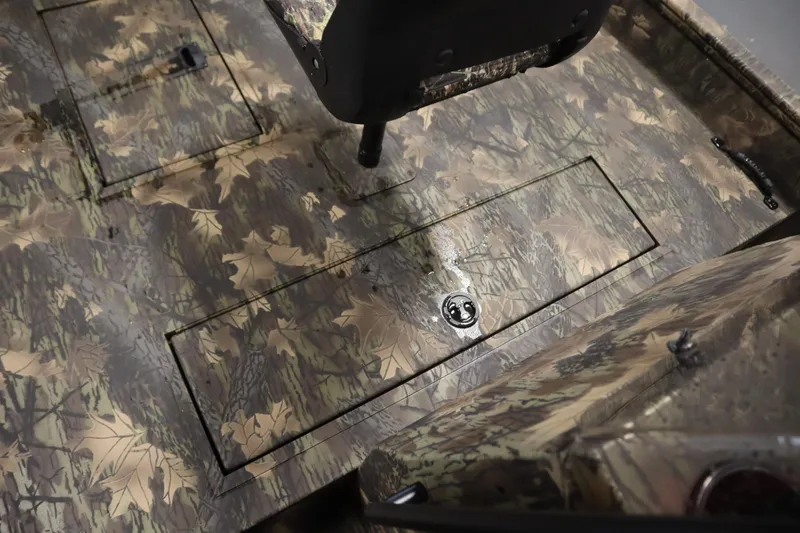 Slide: The Image of 2026 Lowe Roughneck RX2070 CC boat interior with camouflage design and storage compartments. - 14