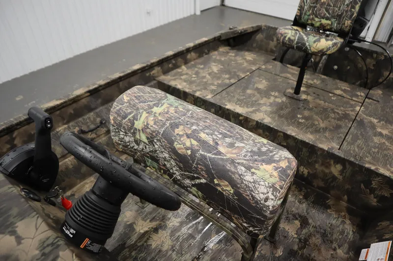 Slide: The Image of 2026 Lowe Roughneck RX2070 CC boat interior with camouflage seating and steering console. - 21