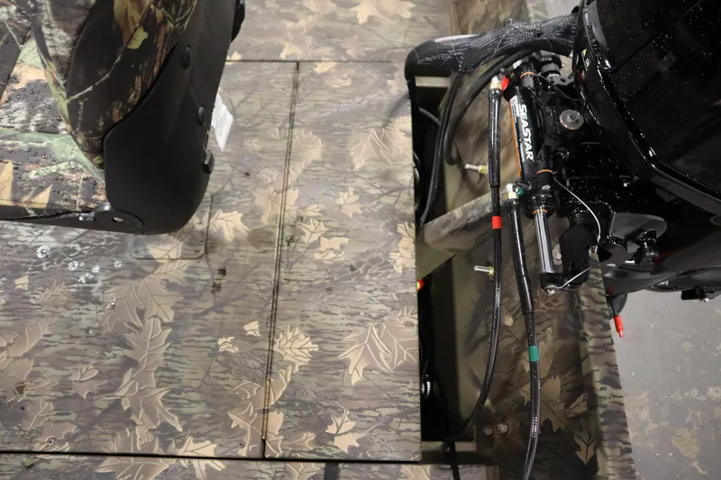 Slide: The Image of 2026 Lowe Roughneck RX2070 CC boat interior with camouflage design and hydraulic steering system. - 26