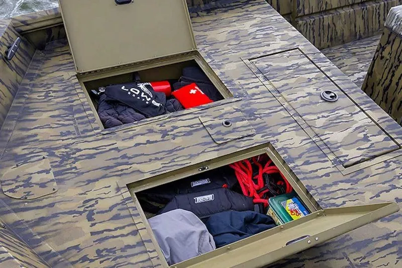 Slide: The Image of Storage compartments on a 2026 Lowe Roughneck RX2070 CC boat, featuring camo design and gear storage. - 36