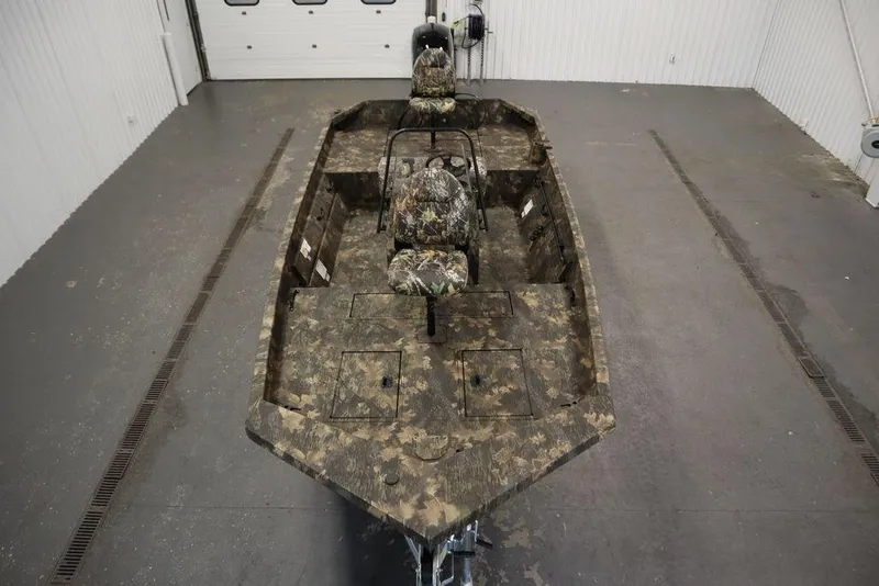 Slide: The Image of 2026 Lowe Roughneck RX2070 CC boat with camouflage design in a garage setting. - 37