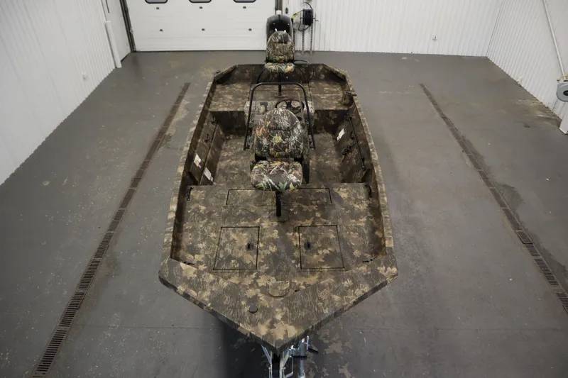 Slide: The Image of 2026 Lowe Roughneck RX2070 CC boat with camouflage design in a garage setting. - 8