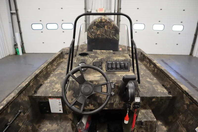 Slide: The Image of 2026 Lowe Roughneck RX1860 Pathfinder boat interior with camouflage design and steering console. - 16