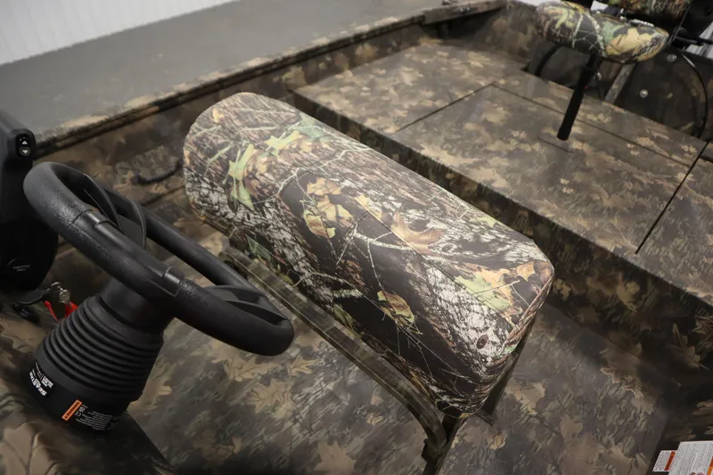 Slide: The Image of 2026 Lowe Roughneck RX1860 Pathfinder boat interior with camouflage seating and steering wheel. - 21