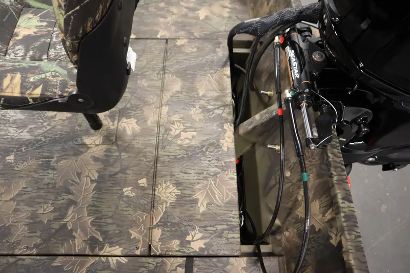 Slide: The Image of 2026 Lowe Roughneck RX1860 Pathfinder interior with camouflage design and hydraulic steering system. - 27