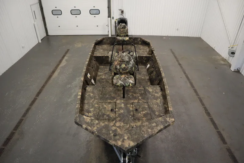 Slide: The Image of 2026 Lowe Roughneck RX1860 Pathfinder boat with camouflage design in a garage setting. - 8