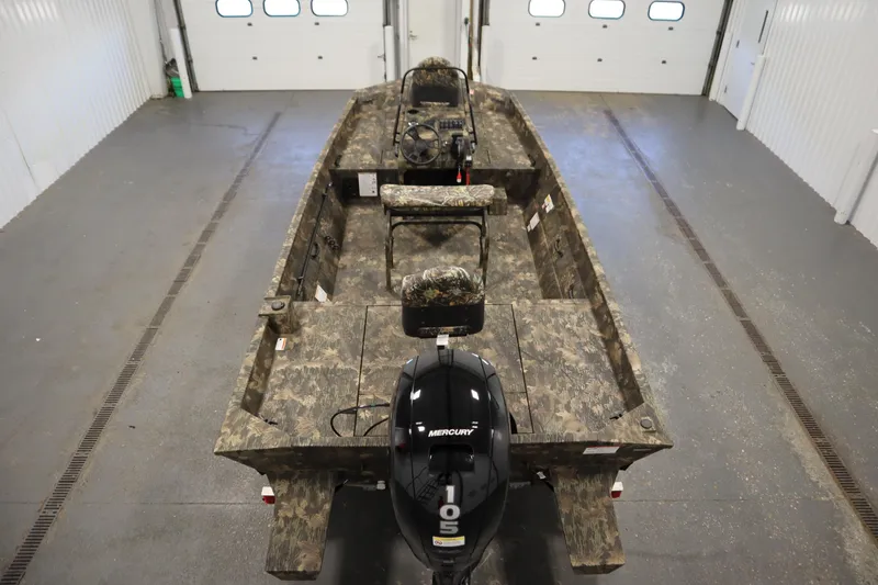 Slide: The Image of 2026 Lowe Roughneck RX1860 Pathfinder boat with camo design in a garage setting. - 9