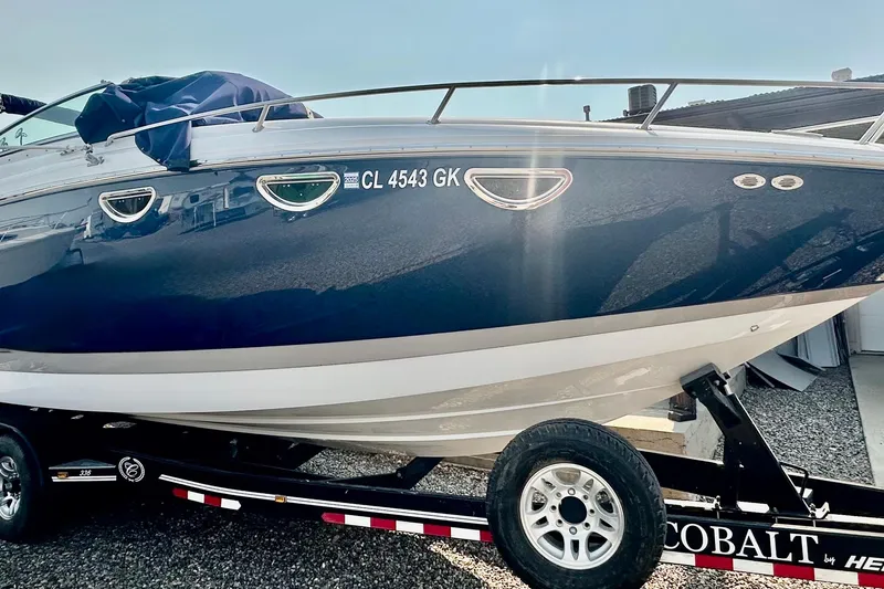 The Image of 2006 Cobalt 323 boat on trailer, blue and white hull, registration CL 4543 GK. - 0