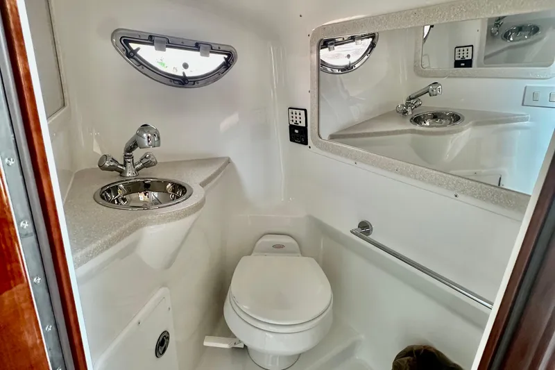 Slide: The Image of Compact bathroom in a 2006 Cobalt 323 boat with sink, toilet, and mirror. - 1