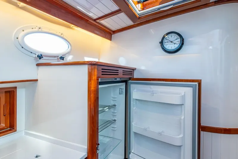 Slide: The Image of Interior of 2019 Hinckley T55 MKII Motor Yacht with open fridge and porthole window. - 25