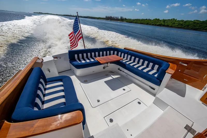 Slide: The Image of 2019 Hinckley T55 MKII Motor Yacht cruising with elegant seating and American flag. - 5