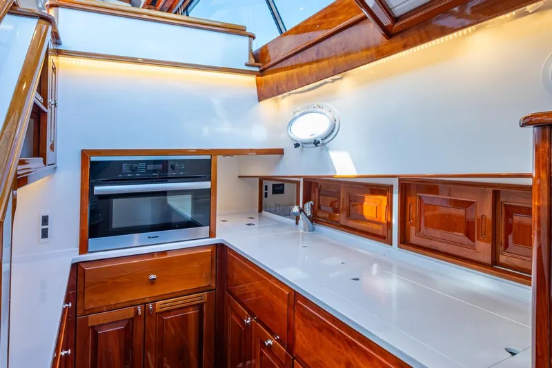 Slide: The Image of Luxurious kitchen interior of 2019 Hinckley T55 MKII Motor Yacht with wood cabinetry and modern appliances. - 22