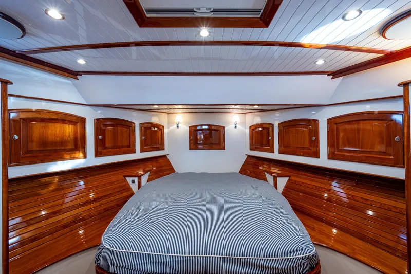Slide: The Image of Luxurious 2019 Hinckley T55 MKII Motor Yacht cabin with elegant wood paneling and cozy bed. - 30