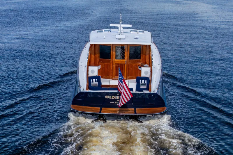Slide: The Image of Hinckley T55 MKII Motor Yacht 2019 cruising on open water, rear view with American flag. - 4