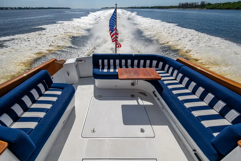 Slide: The Image of Hinckley T55 MKII Motor Yacht 2019, elegant deck with striped seating and American flag. - 6