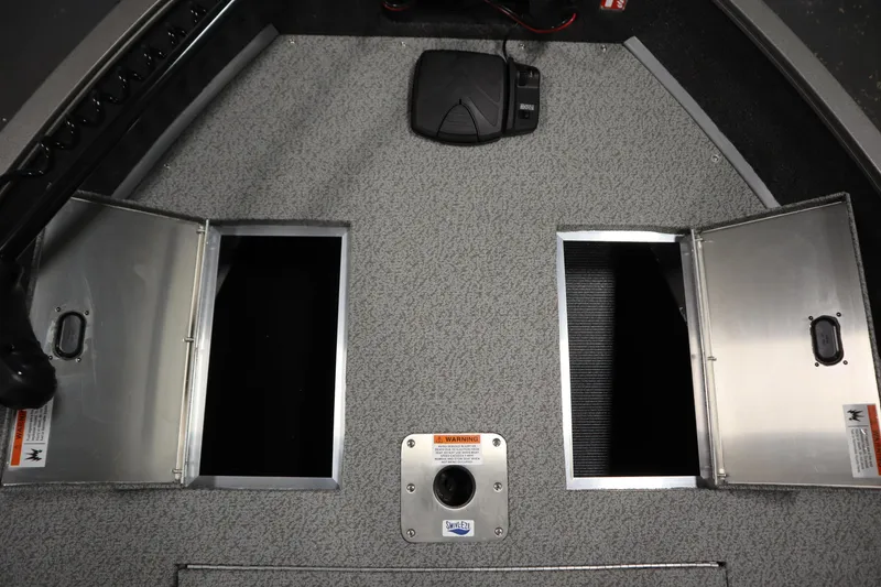 Slide: The Image of 2026 Lowe Fishing Machine 1625SC boat storage compartments with open hatches and foot pedal. - 15