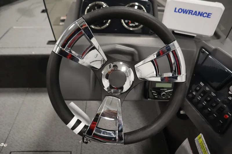 Slide: The Image of 2026 Lowe Fishing Machine 1625SC boat interior with steering wheel and Lowrance electronics. - 20